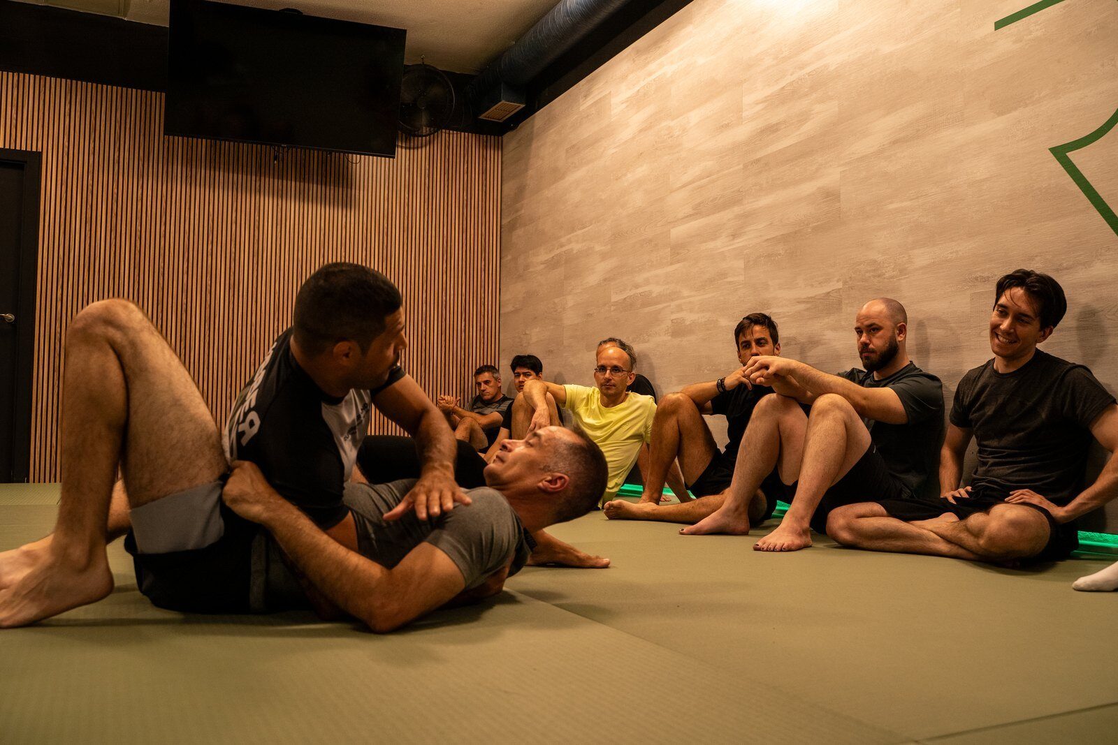 Grupo de alumnos atendiendo una demostracion en el tatami