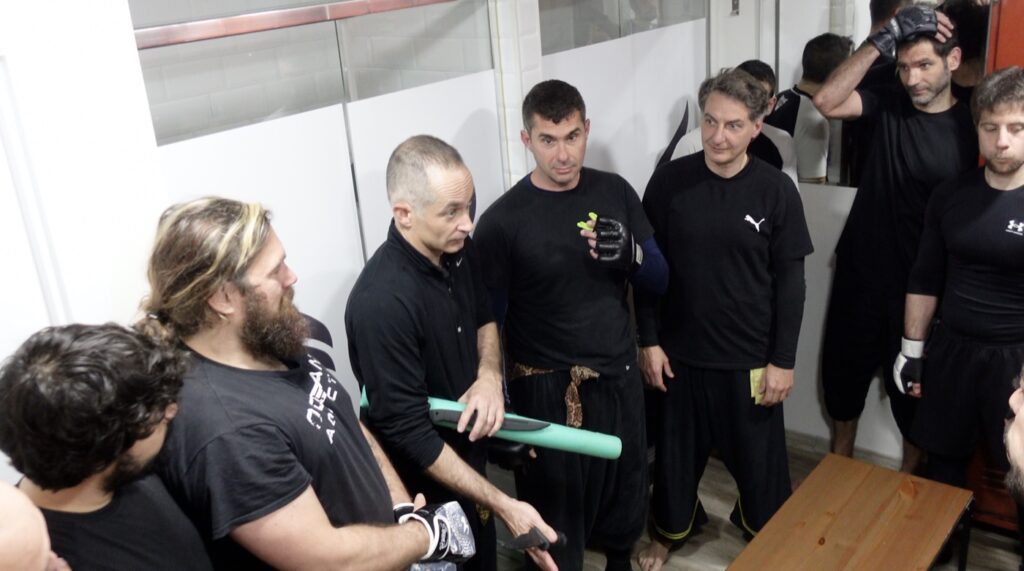 Sebastián Deibe explicando con un bastón de entrenamiento al grupo